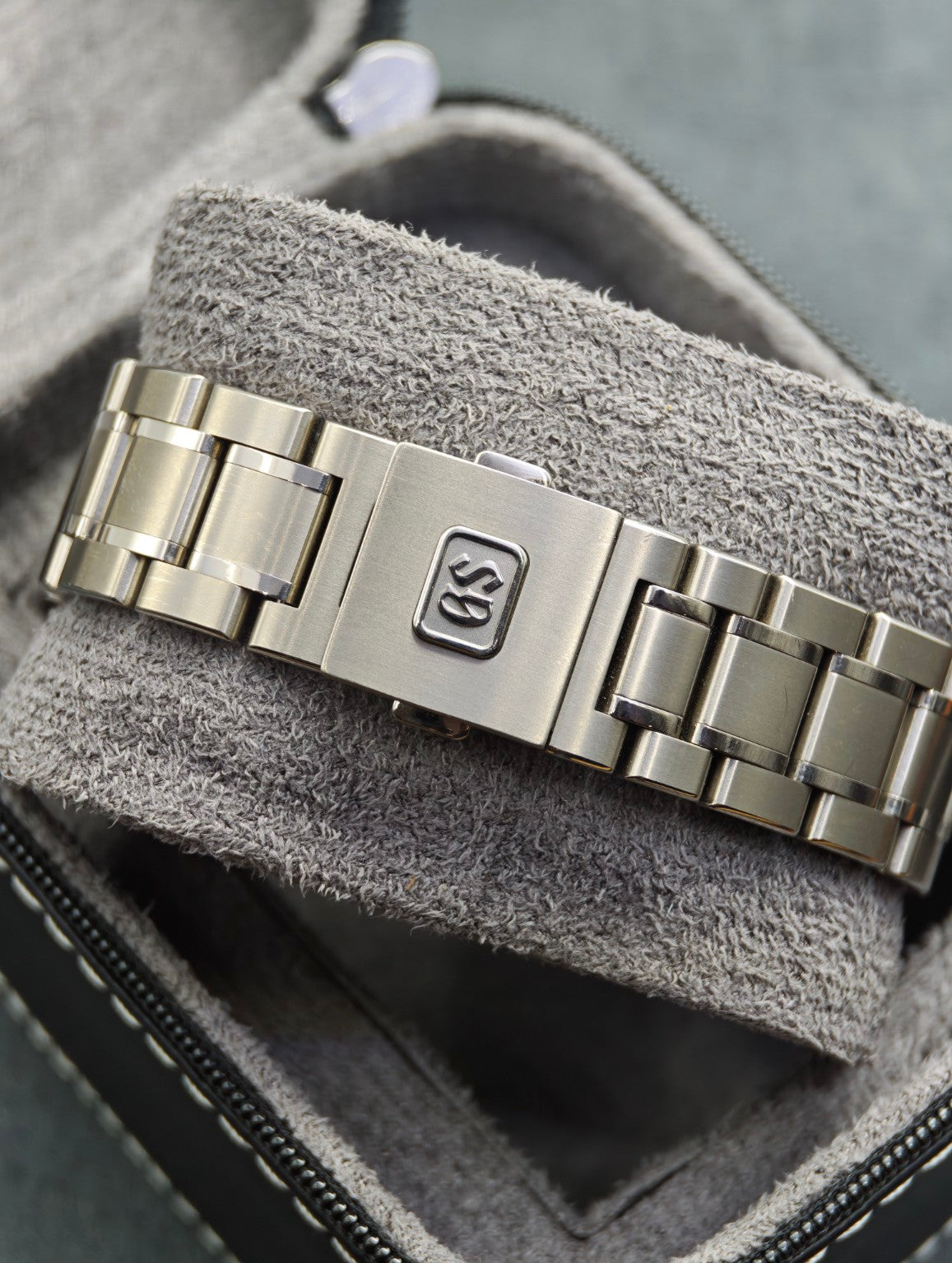 Grand Seiko SBGA259 titanium bracelet and Grand Seiko folding clasp on a grey cushion