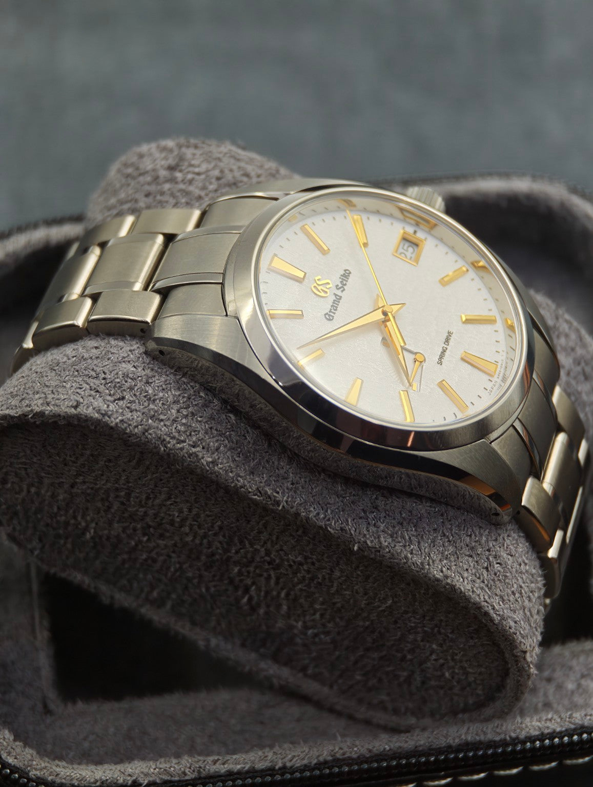 Grand Seiko SBGA259 Golden Snowflake angled dial and titanium bracelet on a grey cushion