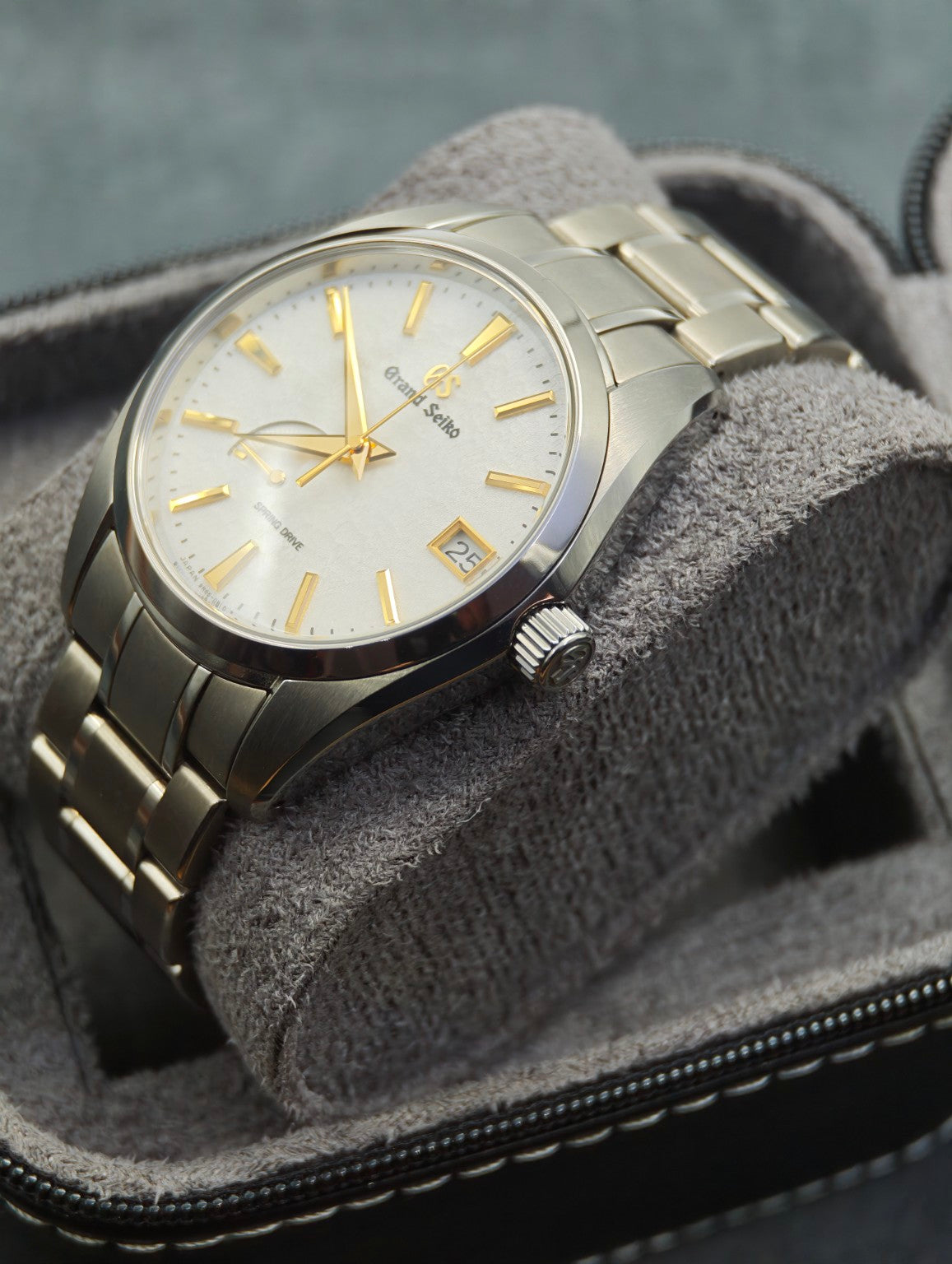 Grand Seiko SBGA259 Golden Snowflake crown-side view on a grey cushion
